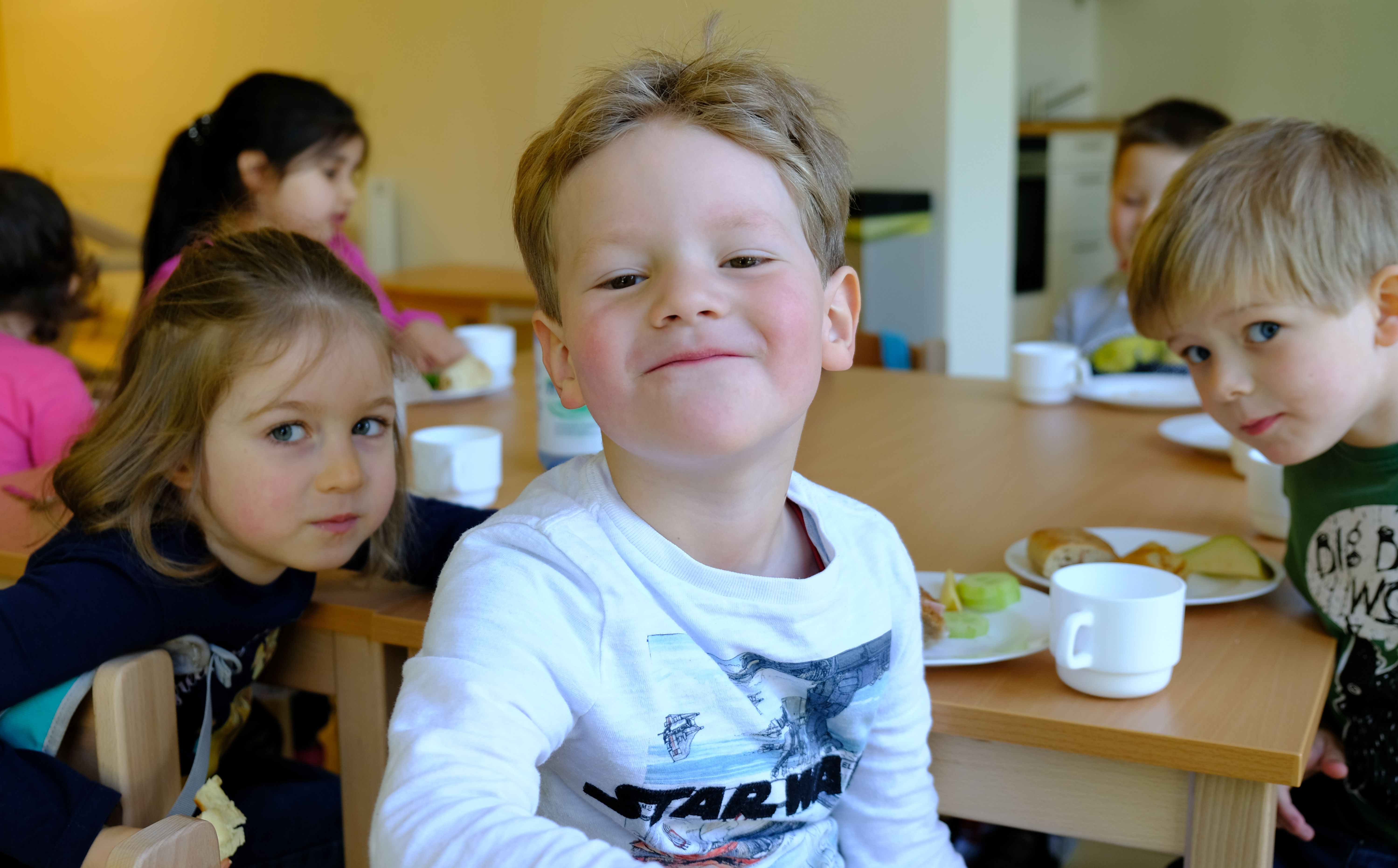 Foto: Kinder beim gemeinsamen Frühstück im Kinder-Café