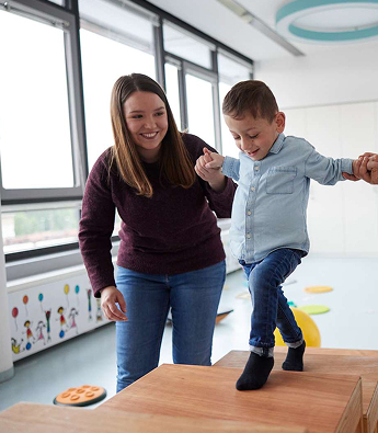 Eine Frau hilft einem kleinen Kind beim Treppe steigen